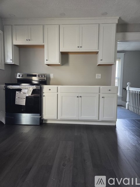 A kitchen with white cabinets and a black stove top oven.