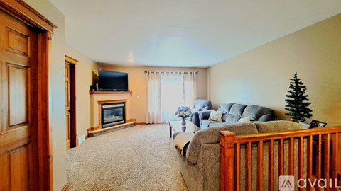 A living room with a grey couch and a wooden floor.