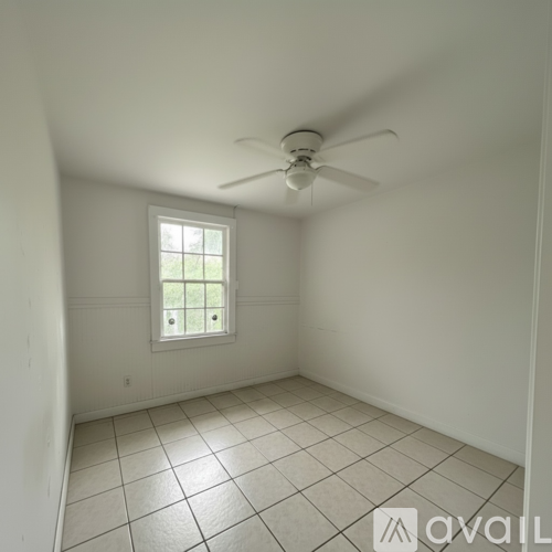 A room with a ceiling fan and a window.