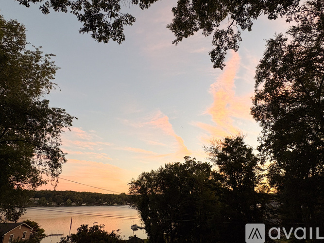 A beautiful sunset view with trees and a lake.