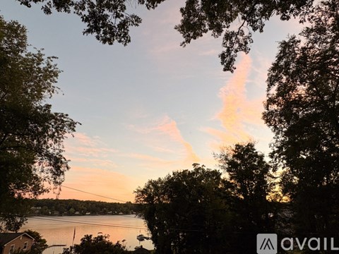 A beautiful sunset view with trees and a lake.