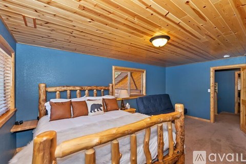A bedroom with a wooden bed frame and a blue wall.
