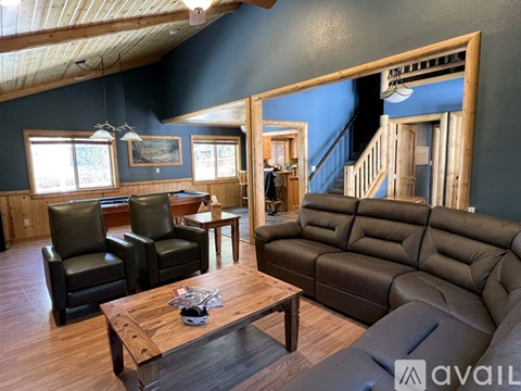 A living room with a brown leather couch and a wooden coffee table.