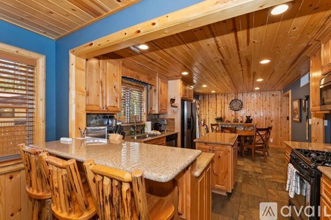 A kitchen with wooden chairs and a granite countertop.
