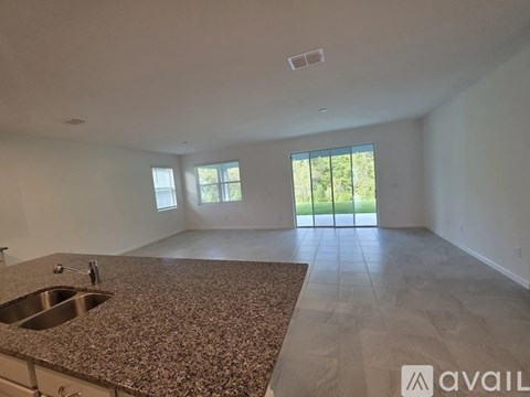A kitchen with granite countertops and a sink is available for rent.