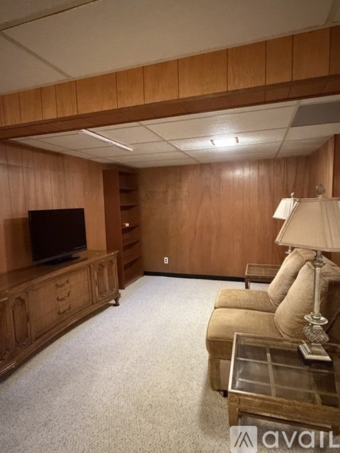 A living room with wooden furniture and a flat screen TV.