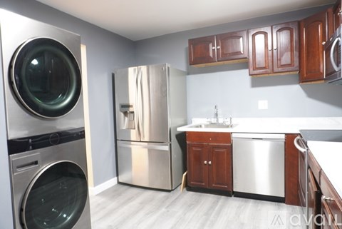 A modern kitchen with a washing machine and a refrigerator.