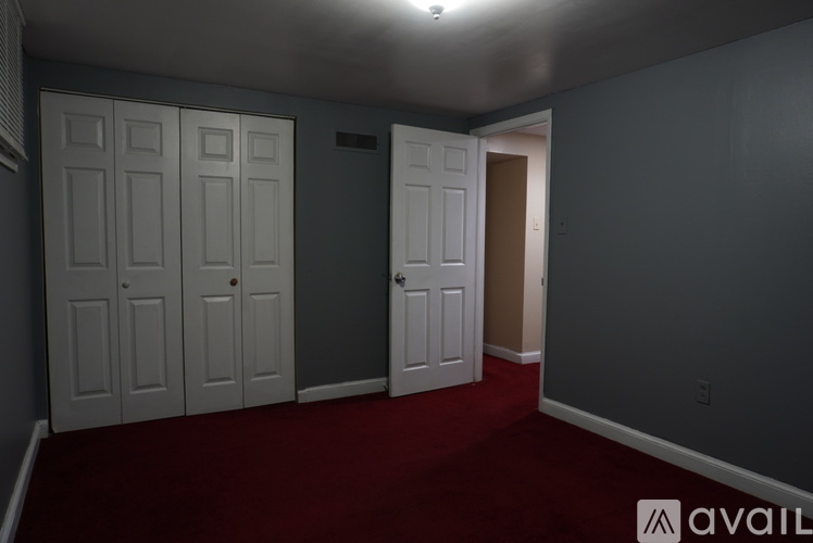 A room with grey walls and red carpet.
