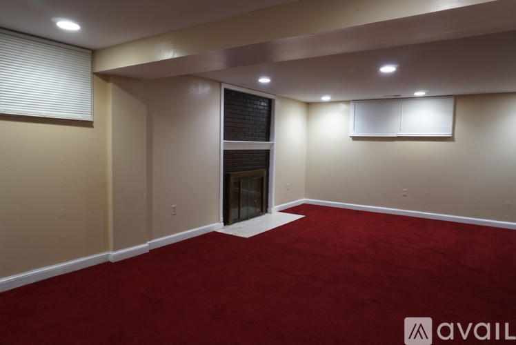 A room with a red carpet and a blackboard on the wall.
