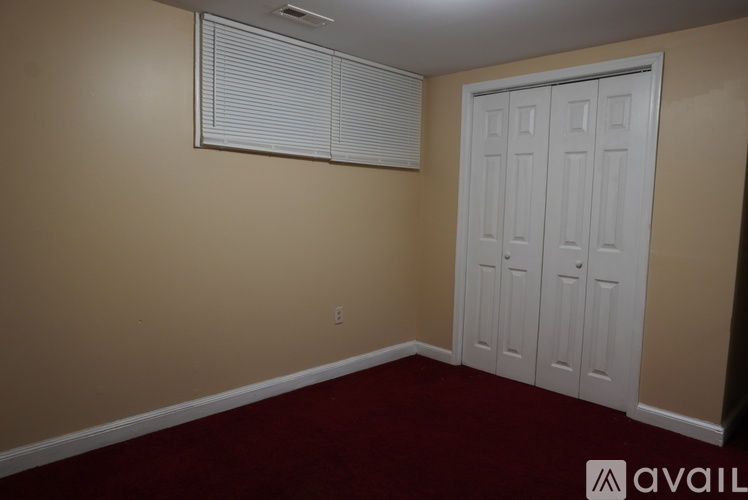 A room with a white door and a window with blinds.