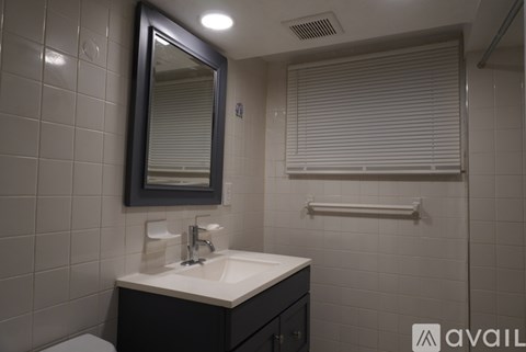 A bathroom with a sink, mirror, and toilet.