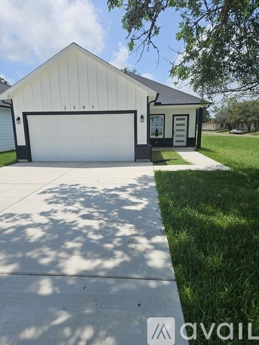 A two-car garage with a white door and a black roof.