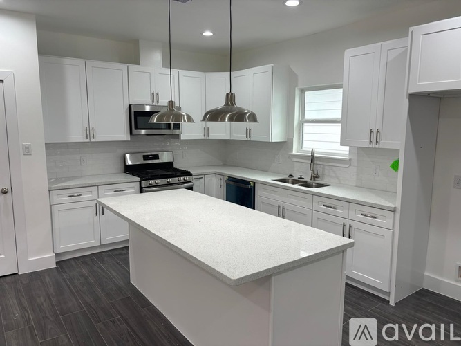 A modern kitchen with white cabinets and a large island.