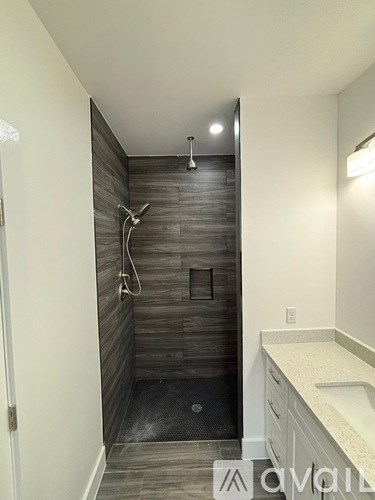 A bathroom with a walk-in shower and a white counter.