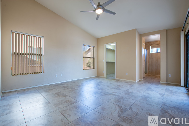 A spacious room with a ceiling fan and tiled flooring.