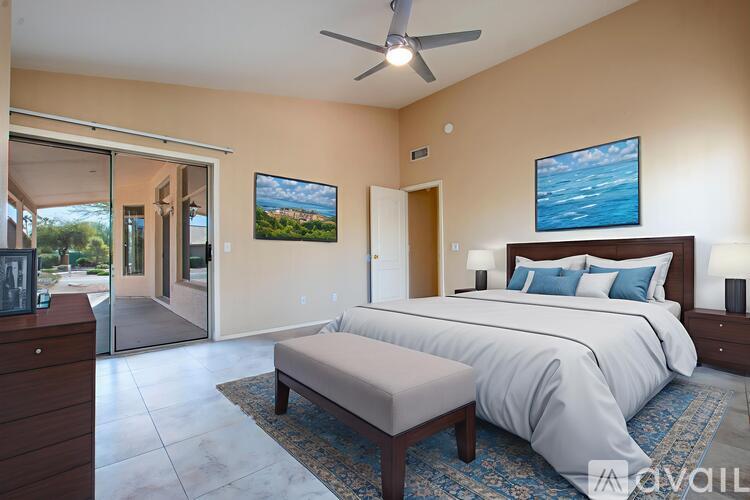 A bedroom with a large bed and a ceiling fan.