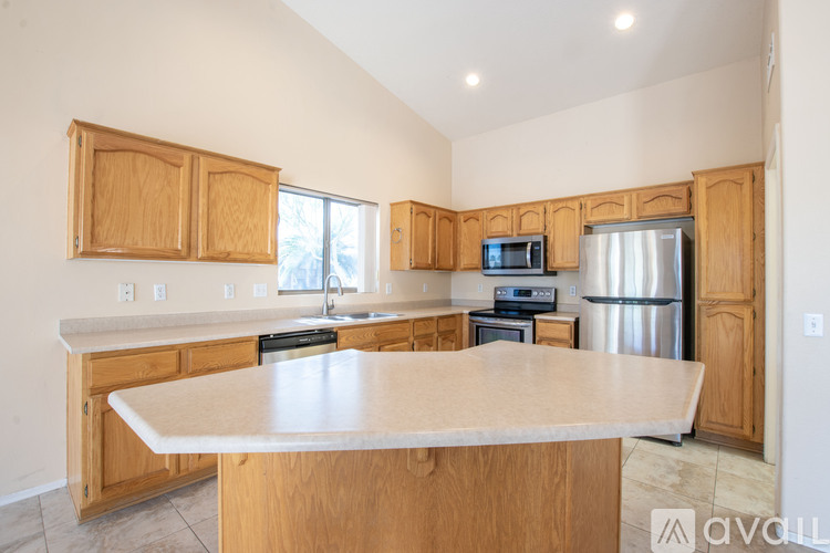 A kitchen with wooden cabinets and a large island.