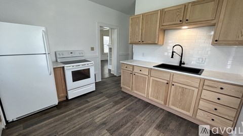 A kitchen with wooden cabinets and a white fridge.