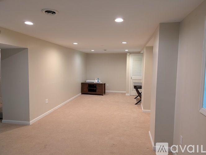 A spacious room with a carpeted floor and a ceiling light.