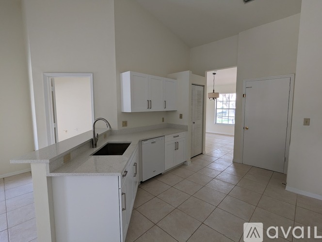 A kitchen with white cabinets and a marble countertop.