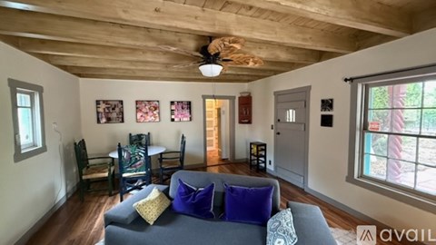 A living room with a grey couch and a wooden ceiling.
