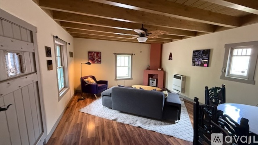 A living room with a grey couch and a wooden floor.