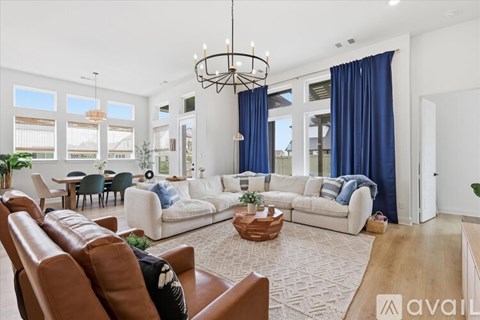 A living room with white furniture and a large window.