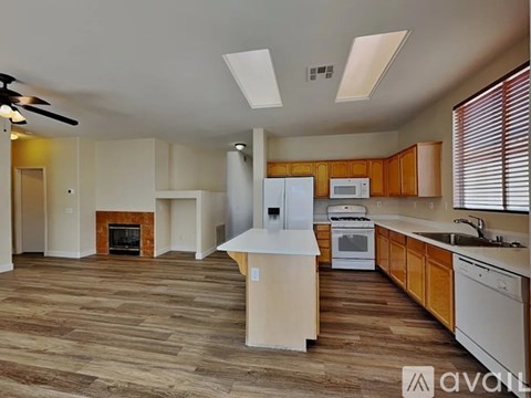 A spacious kitchen with wooden flooring and modern appliances.