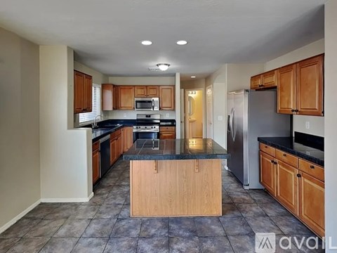 A kitchen with wooden cabinets and a granite countertop.