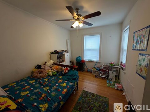 A room with a bed, a ceiling fan, and a rug.