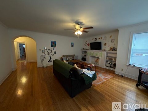 A living room with a green couch and a ceiling fan.