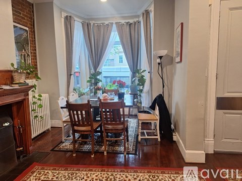 A living room with a fireplace and a dining table set for four.