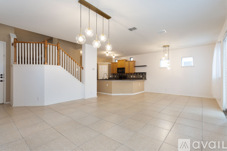 A spacious living room with a staircase and a bar area.