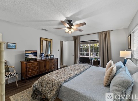 A bedroom with a large bed and a ceiling fan.