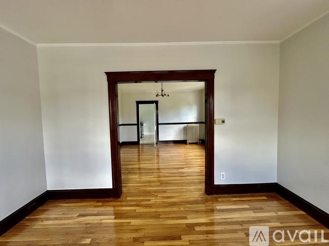 A room with wooden floors and a large mirror on the wall.