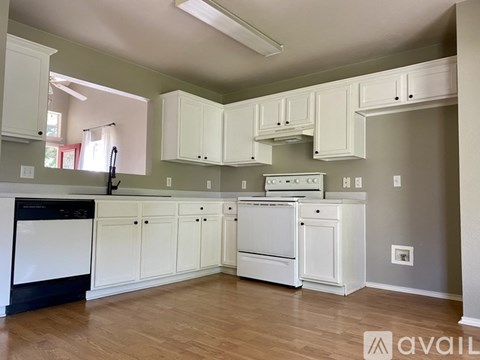 A kitchen with white cabinets and appliances.