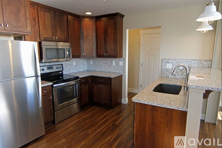 A kitchen with wooden cabinets and a stainless steel refrigerator.