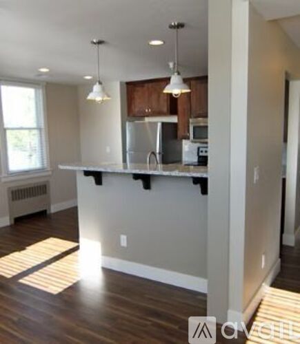 A kitchen with a white counter and wooden cabinets.