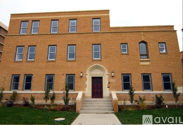 A red brick building with a white door and windows.