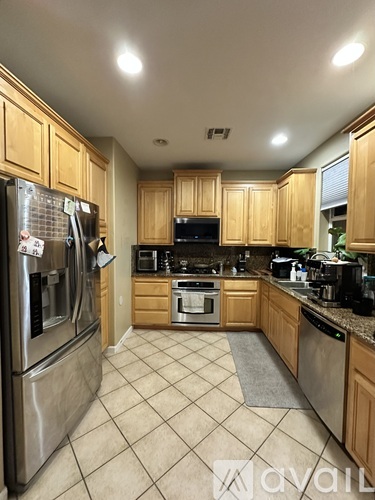 A kitchen with wooden cabinets and a tile floor.