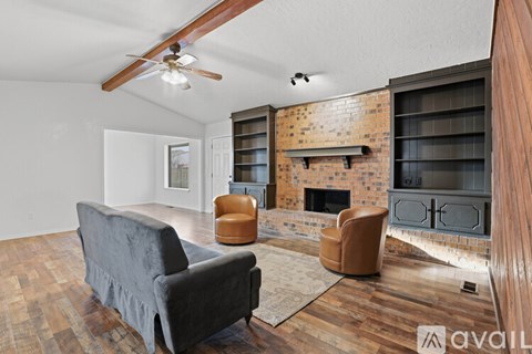 A living room with a grey couch and a fireplace.
