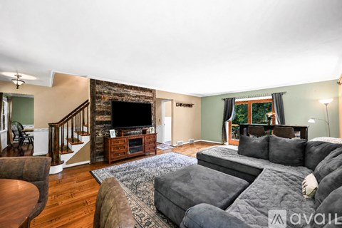 A living room with a grey couch and a fireplace.