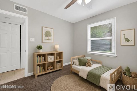 A bedroom with a bed, a window, a bookshelf, and a rug.