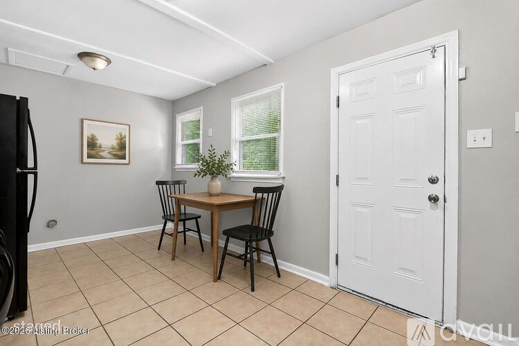 A dining room with a table and chairs.