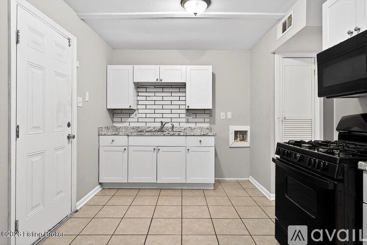 A kitchen with white cabinets and a black stove top oven.