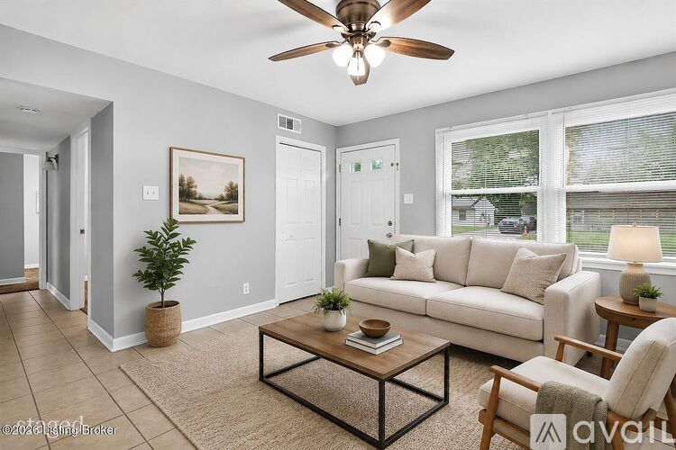 A living room with a couch, chair, and a ceiling fan.