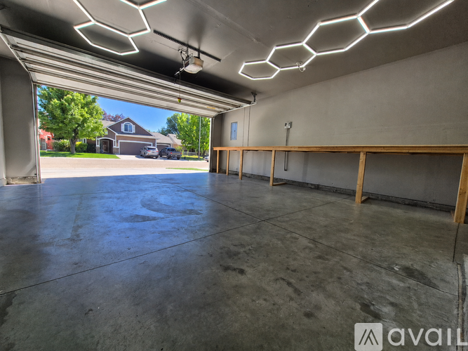 A spacious garage with a concrete floor and a ceiling with hexagonal lighting fixtures.