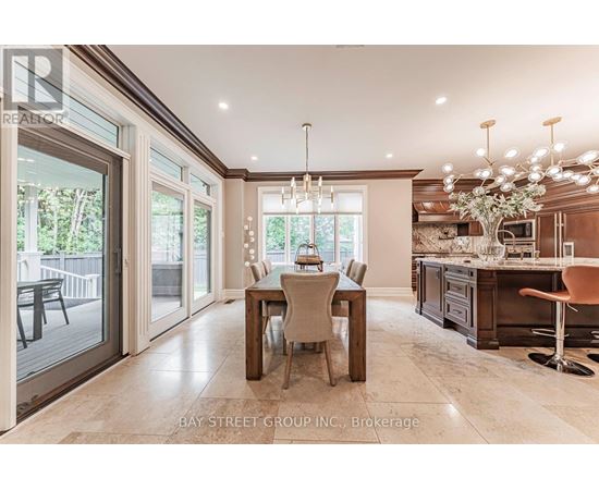 A dining room with a table set for four and a kitchen area in the background.