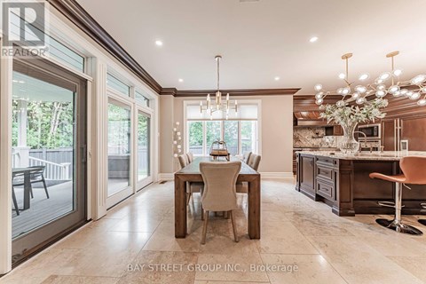 A dining room with a table set for four and a kitchen area in the background.