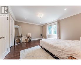 A bedroom with a large bed and a white rug.